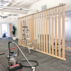 Wood slat dividing wall wiht green logo for lobby/reception desk area at the San Francisco office of Neustar, an American technology company that provides real-time information and analytics.