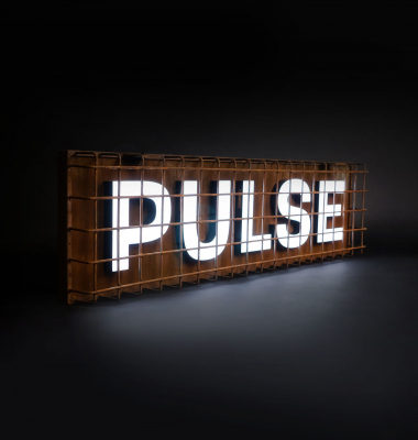 Industrial, caged, rusty metal illuminated sign for Pulse, a fitness studio at Newtown Athletic Club, a premiere family fitness and wellness center serving residents of Newtown, PA