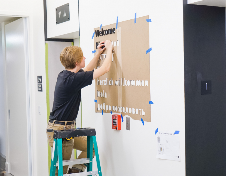 Black dimensional letters on wall listing various languages for the San Francisco office of Roostify, an integrated digital mortgage software platform.