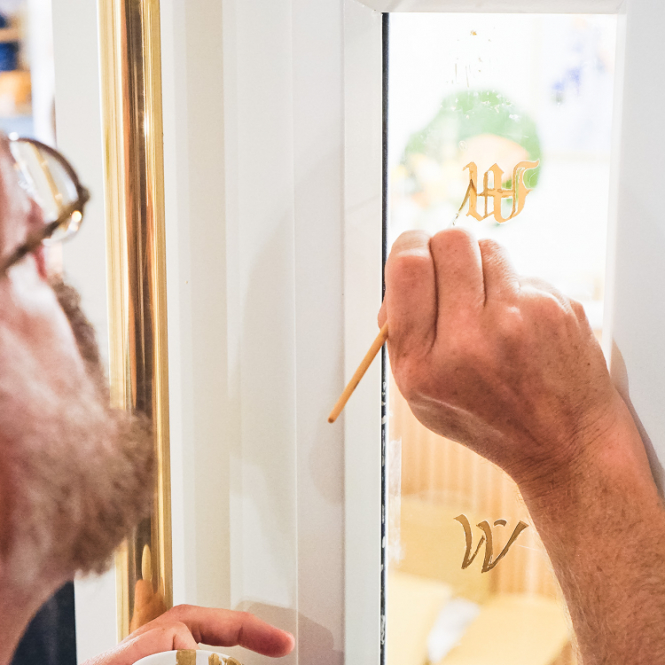 23k gold leaf signage honoring the names of iconic women, on glass doors at The Wing San Francisco, a co-working space for women.