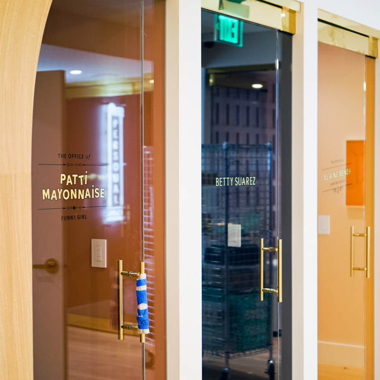 23k gold leaf signage honoring the names of iconic women, on glass doors at The Wing San Francisco, a co-working space for women.