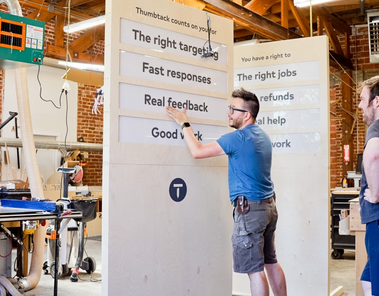 Illuminated, light wood freestanding panel sign for Thumbtack's special events around the country.