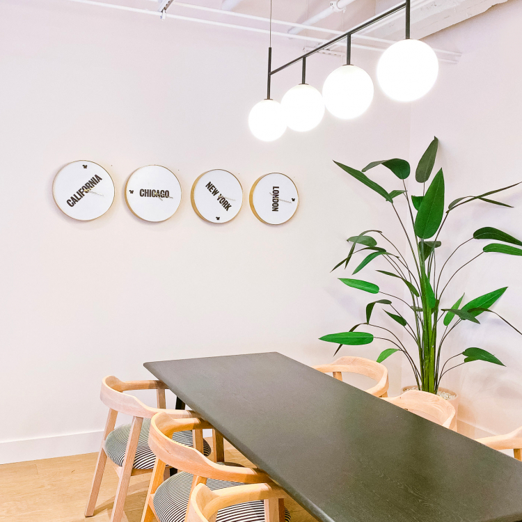 Custom brass and white international time zone clock wall for the San Francisco expansion of The Wing, a network of work and community spaces designed for women.